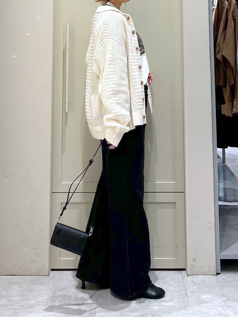 ブラック系のデニムパンツ、ブラック系のサンダル、ブラック系のボディバッグ/ウエストポーチを着用したレディースの春コーディネートの5枚目の写真