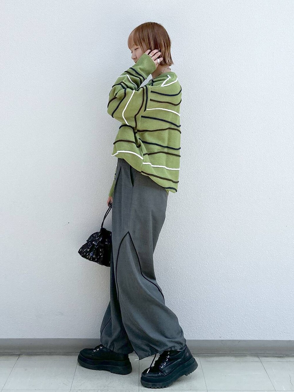 グレー系のその他パンツ、ブラック系のブーツ、グリーン系のニット/セーターを着用したレディースの冬コーディネートの2枚目の写真