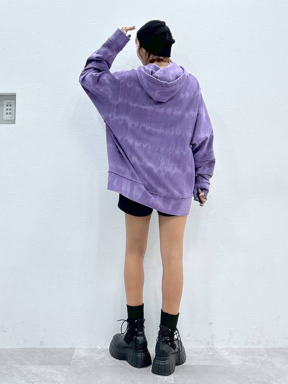 パープル系のパーカー、ブラック系のその他パンツ、ブラック系のブーツを着用したレディースの冬コーディネートの3枚目の写真