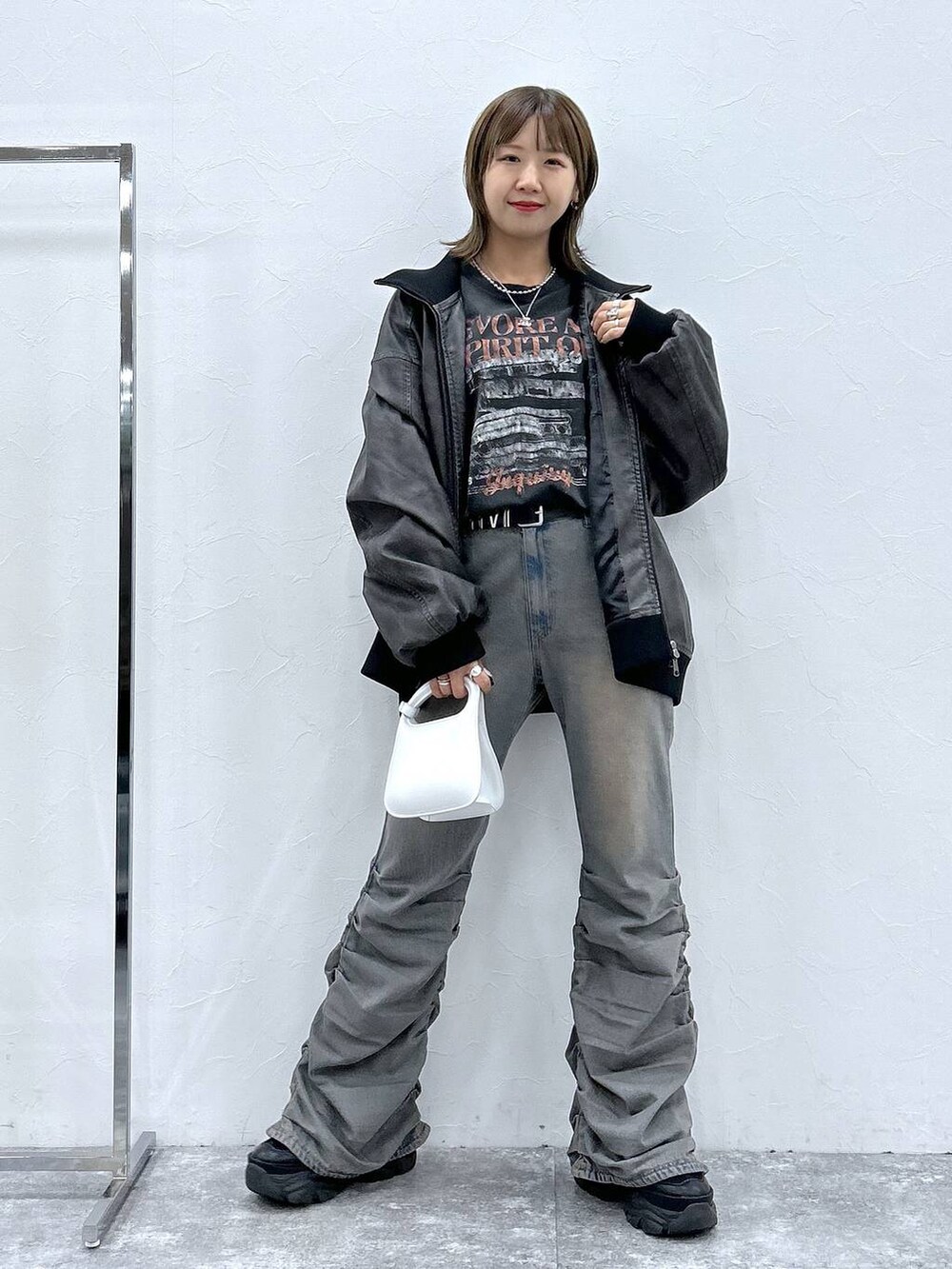 ブラック系のスニーカー、ブルー系のデニムパンツ、ブラック系のブルゾンを着用したレディースの秋コーディネートの7枚目の写真