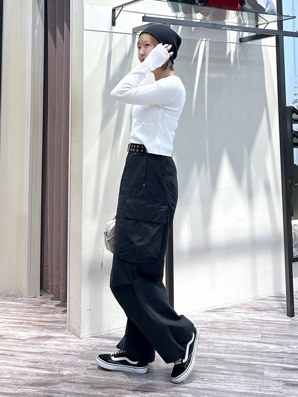 ホワイト系のニット/セーター、ブラック系のカーゴパンツ、ベージュ系のボストンバッグを着用したレディースの春コーディネートの2枚目の写真