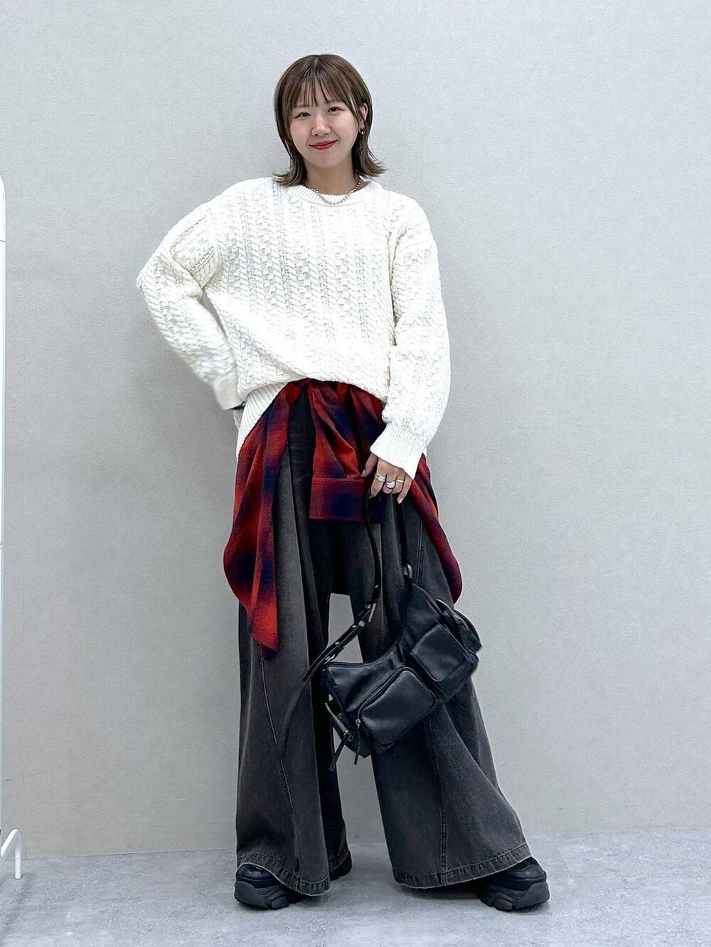 ブラック系のスニーカー、ブラック系のデニムパンツ、ブラック系のショルダーバッグを着用したレディースの冬コーディネートの7枚目の写真