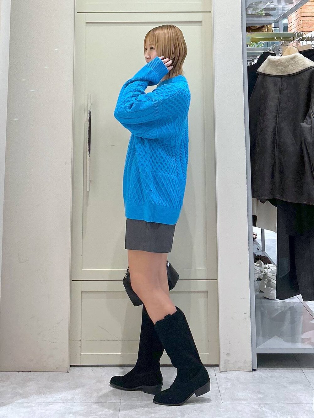 グレー系のその他パンツ、ブルー系のニット/セーター、ブラック系のショルダーバッグを着用したレディースの冬コーディネートの2枚目の写真