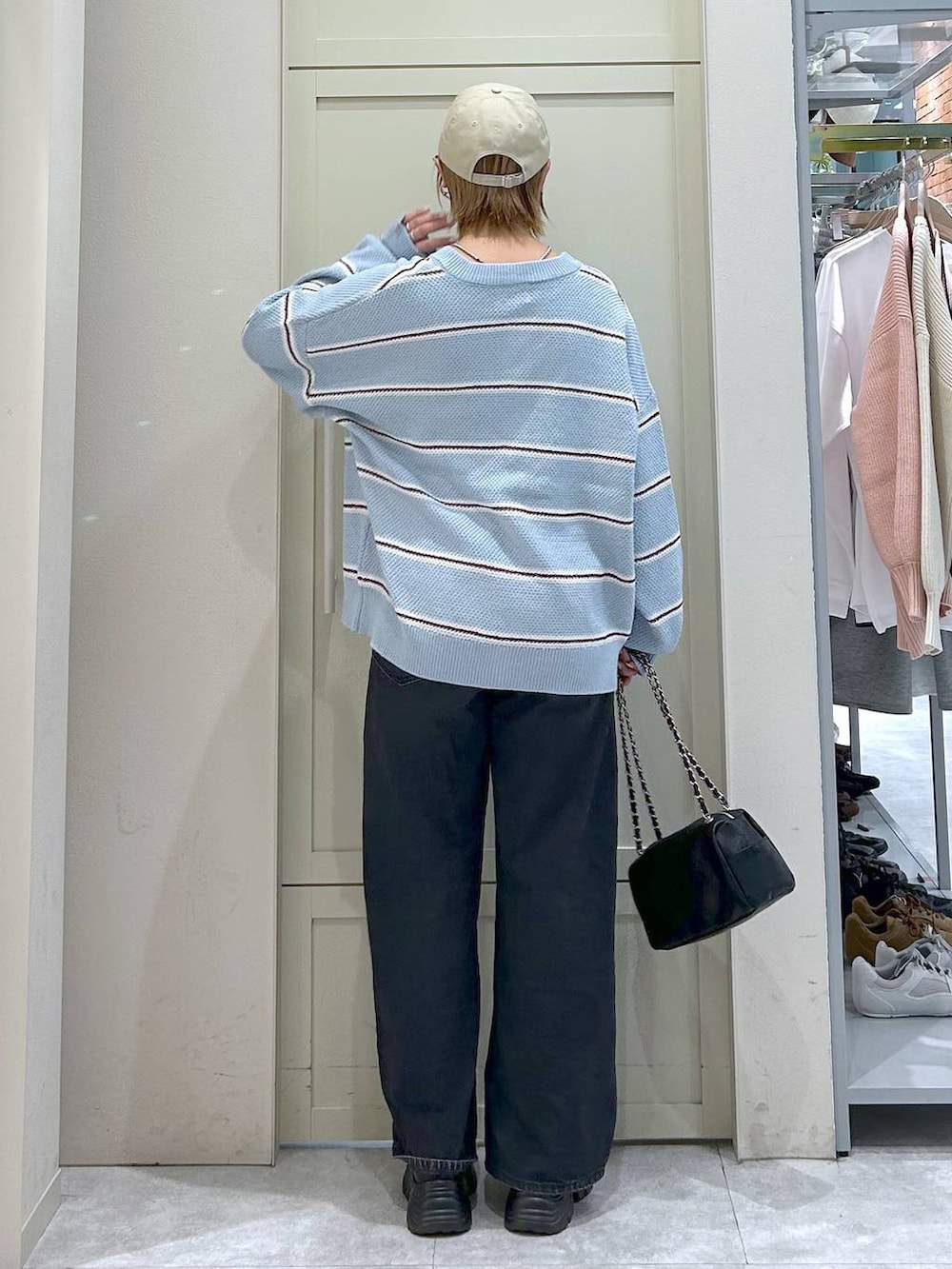 ブラック系のデニムパンツ、ブラック系のショルダーバッグ、ブラック系のローファーを着用したレディースの冬コーディネートの3枚目の写真