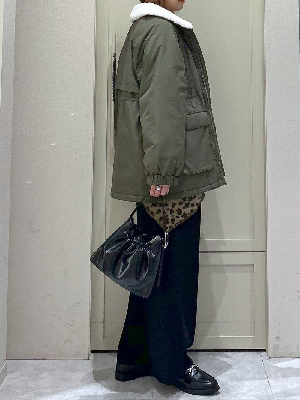 ブラック系のスラックス、グリーン系のその他アウター、ブラック系のローファーを着用したレディースの冬コーディネートの5枚目の写真