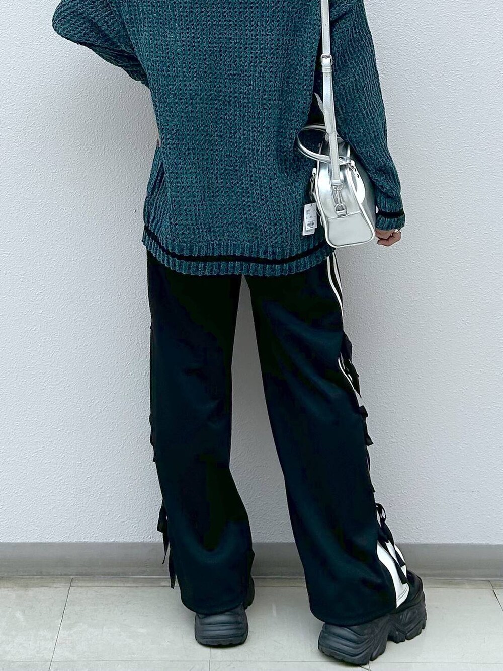 ブラック系のスニーカー、ブラック系のその他パンツ、シルバー系のショルダーバッグを着用したレディースの秋コーディネートの6枚目の写真