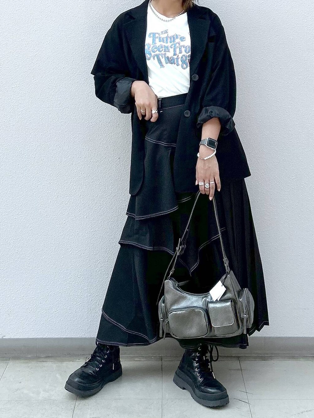 ブラック系のテーラードジャケット、ブラック系のブーツ、ベージュ系のTシャツ/カットソーを着用したレディースの秋コーディネートの4枚目の写真