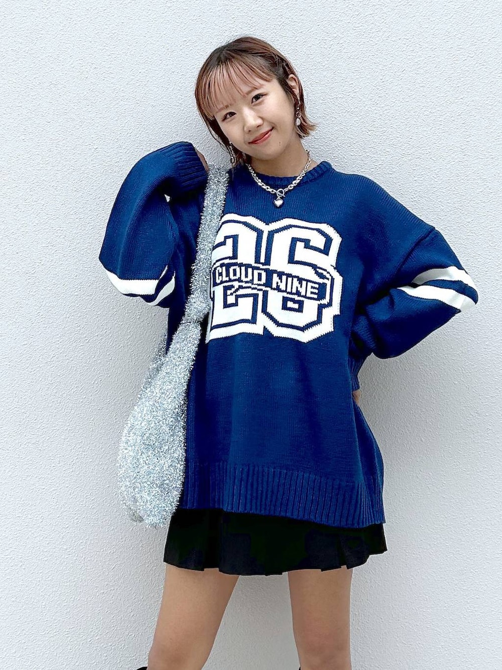 シルバー系のトートバッグ、ブラック系のブーツ、ブラック系のその他パンツを着用したレディースの秋コーディネートの4枚目の写真