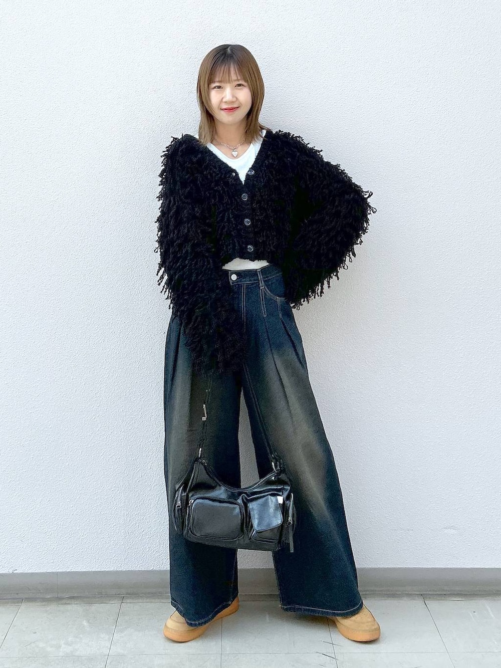 ブラック系のショルダーバッグ、ブラック系のカーディガン/ボレロ、ホワイト系のTシャツ/カットソーを着用したレディースの冬コーディネートの7枚目の写真