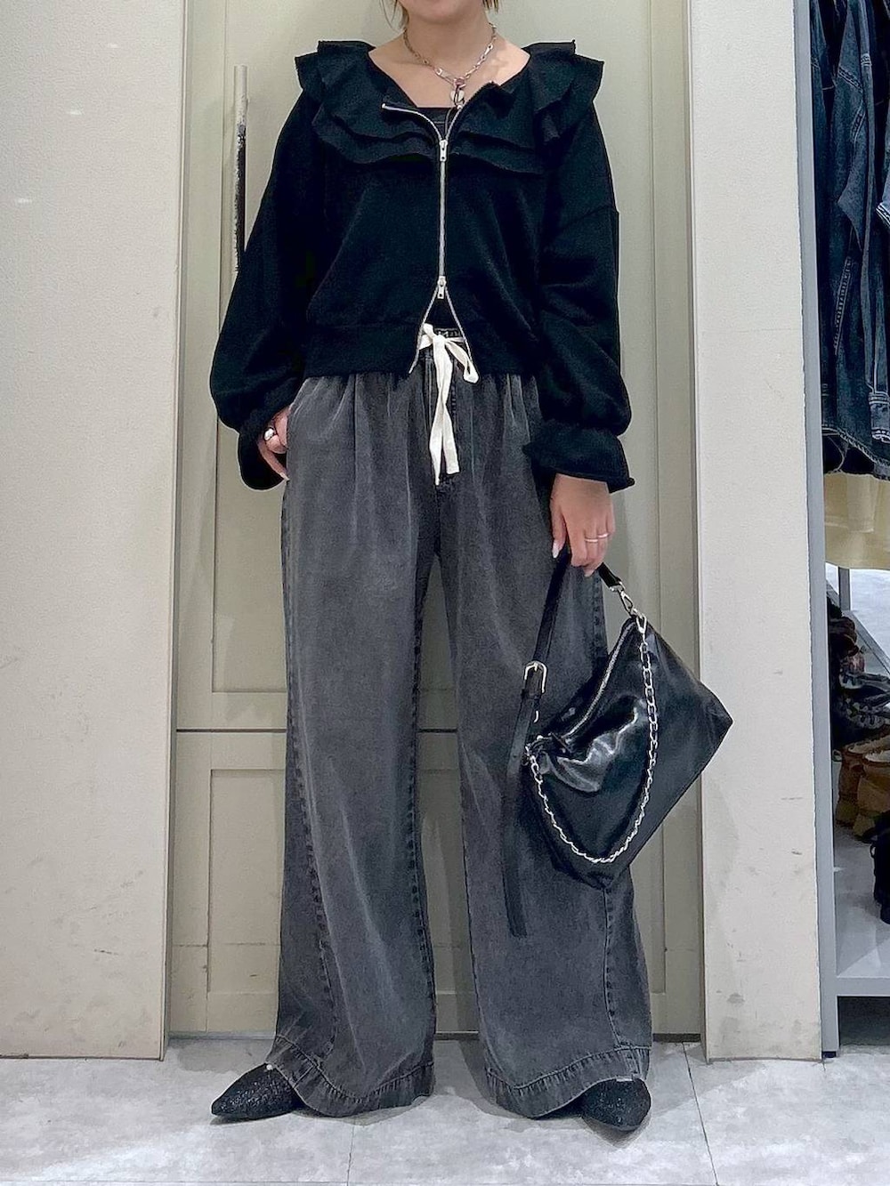 ブラック系のデニムパンツ、ブラック系のショルダーバッグ、ブラック系のパンプスを着用したレディースの冬コーディネートの4枚目の写真