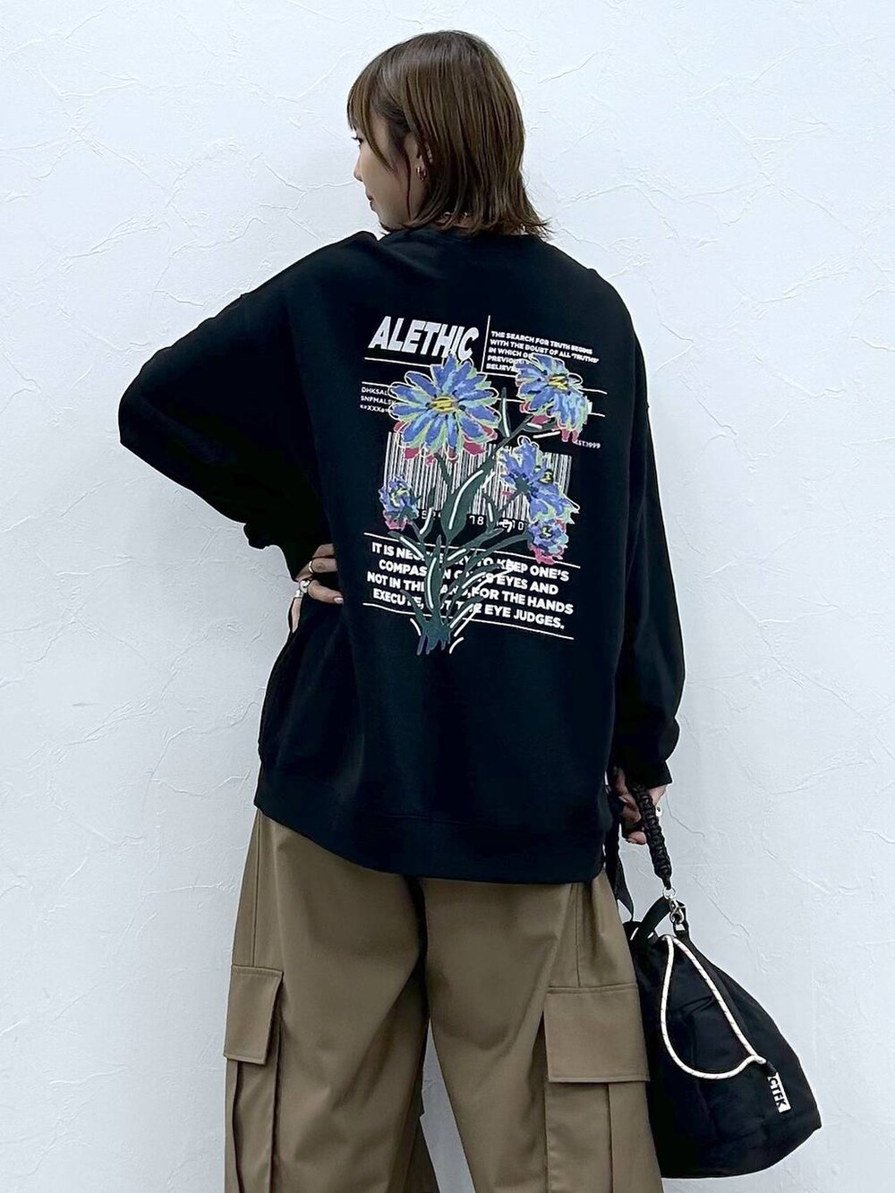 ブラック系のスニーカー、ブラック系のスウェット、ブラック系のショルダーバッグを着用したレディースの秋コーディネートの6枚目の写真