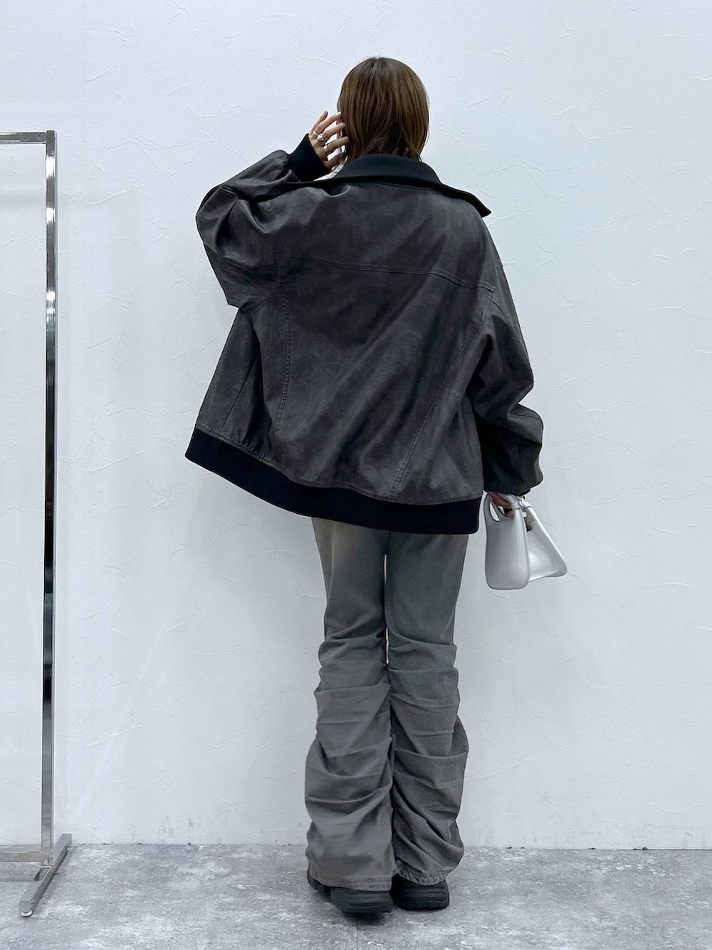 ブラック系のスニーカー、ブルー系のデニムパンツ、ブラック系のブルゾンを着用したレディースの秋コーディネートの3枚目の写真