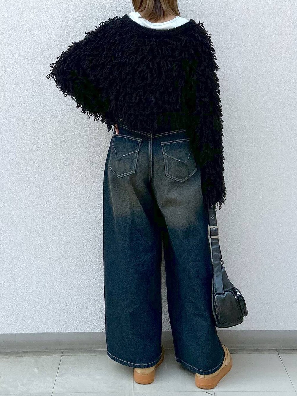 ブラック系のショルダーバッグ、ブラック系のカーディガン/ボレロ、ホワイト系のTシャツ/カットソーを着用したレディースの冬コーディネートの6枚目の写真