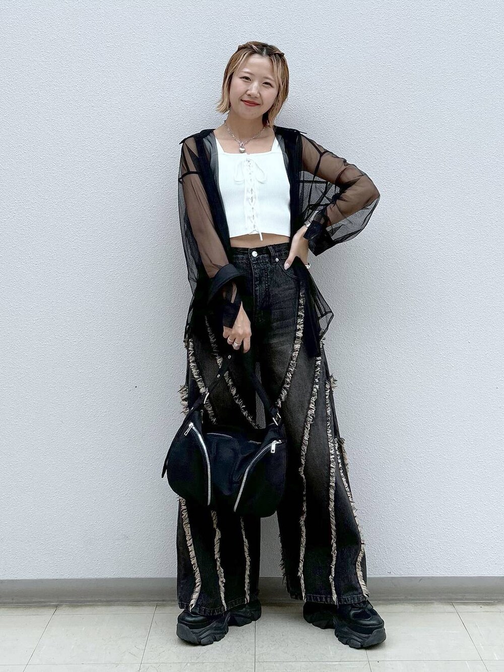 ブラック系のスニーカー、ホワイト系のタンクトップ、ブラック系のシャツ/ブラウスを着用したレディースの夏コーディネートの7枚目の写真