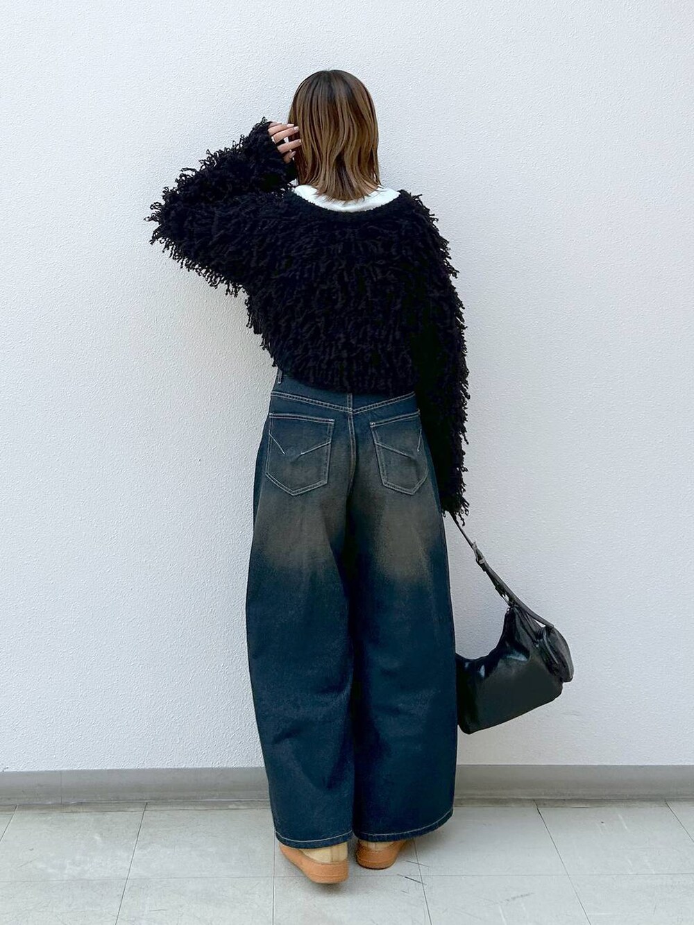 ブラック系のショルダーバッグ、ブラック系のカーディガン/ボレロ、ホワイト系のTシャツ/カットソーを着用したレディースの冬コーディネートの3枚目の写真