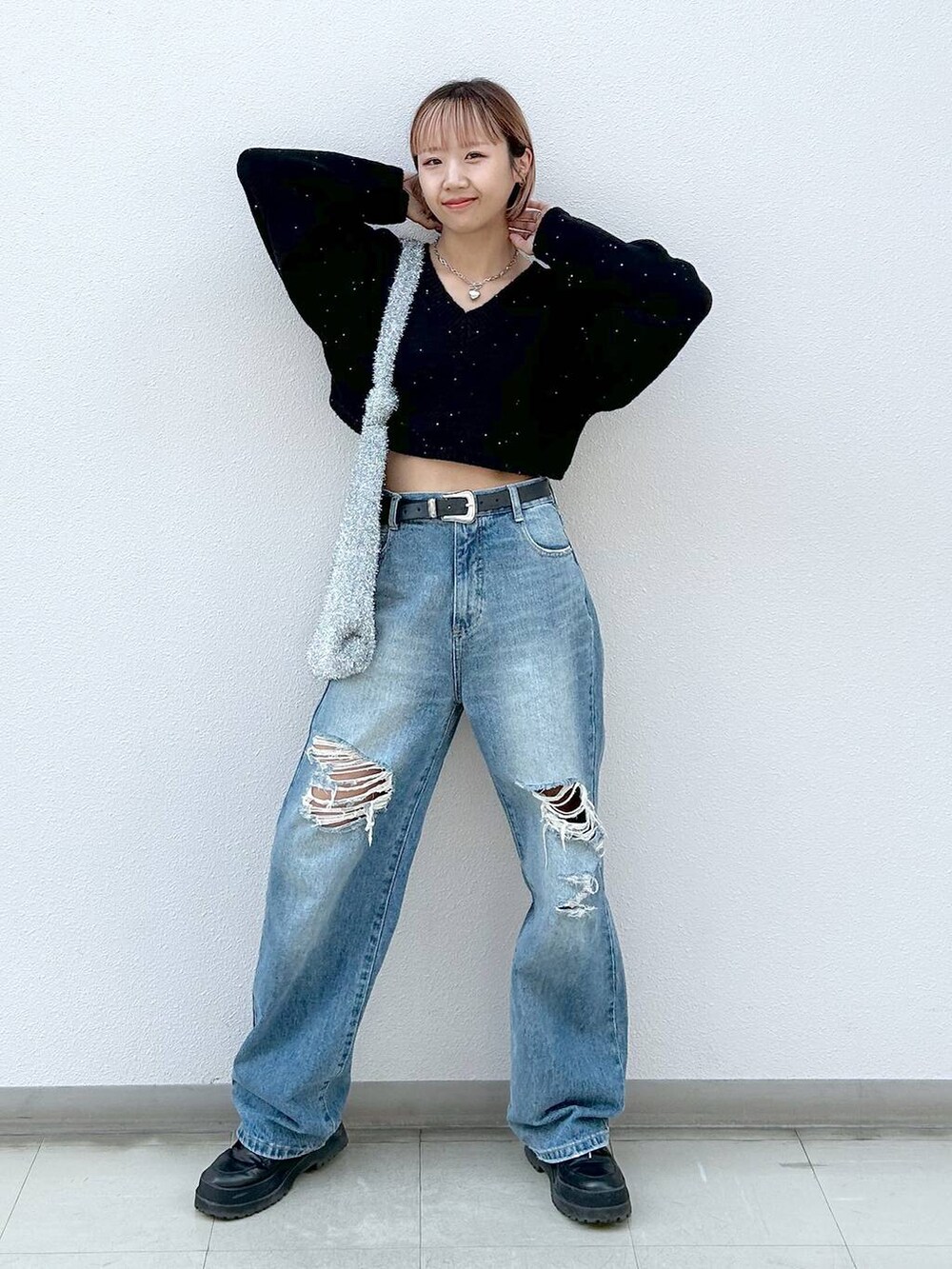 ブラック系のブーツ、ブルー系のデニムパンツ、シルバー系のトートバッグを着用したレディースの冬コーディネートの7枚目の写真