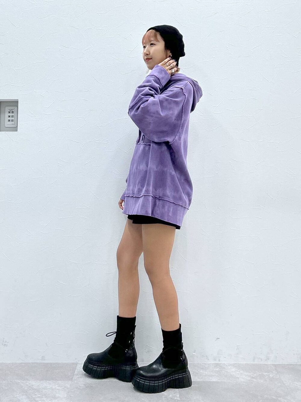 パープル系のパーカー、ブラック系のその他パンツ、ブラック系のブーツを着用したレディースの冬コーディネートの2枚目の写真