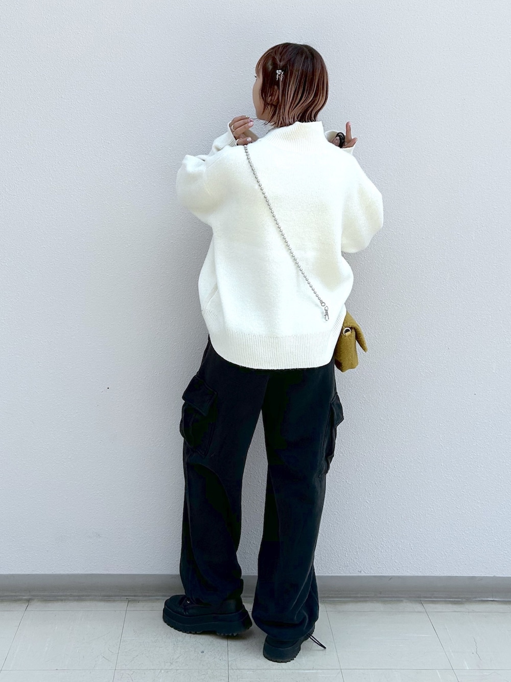 ホワイト系のニット/セーター、ブラック系のカーゴパンツ、イエロー系のショルダーバッグを着用したレディースの秋コーディネートの3枚目の写真