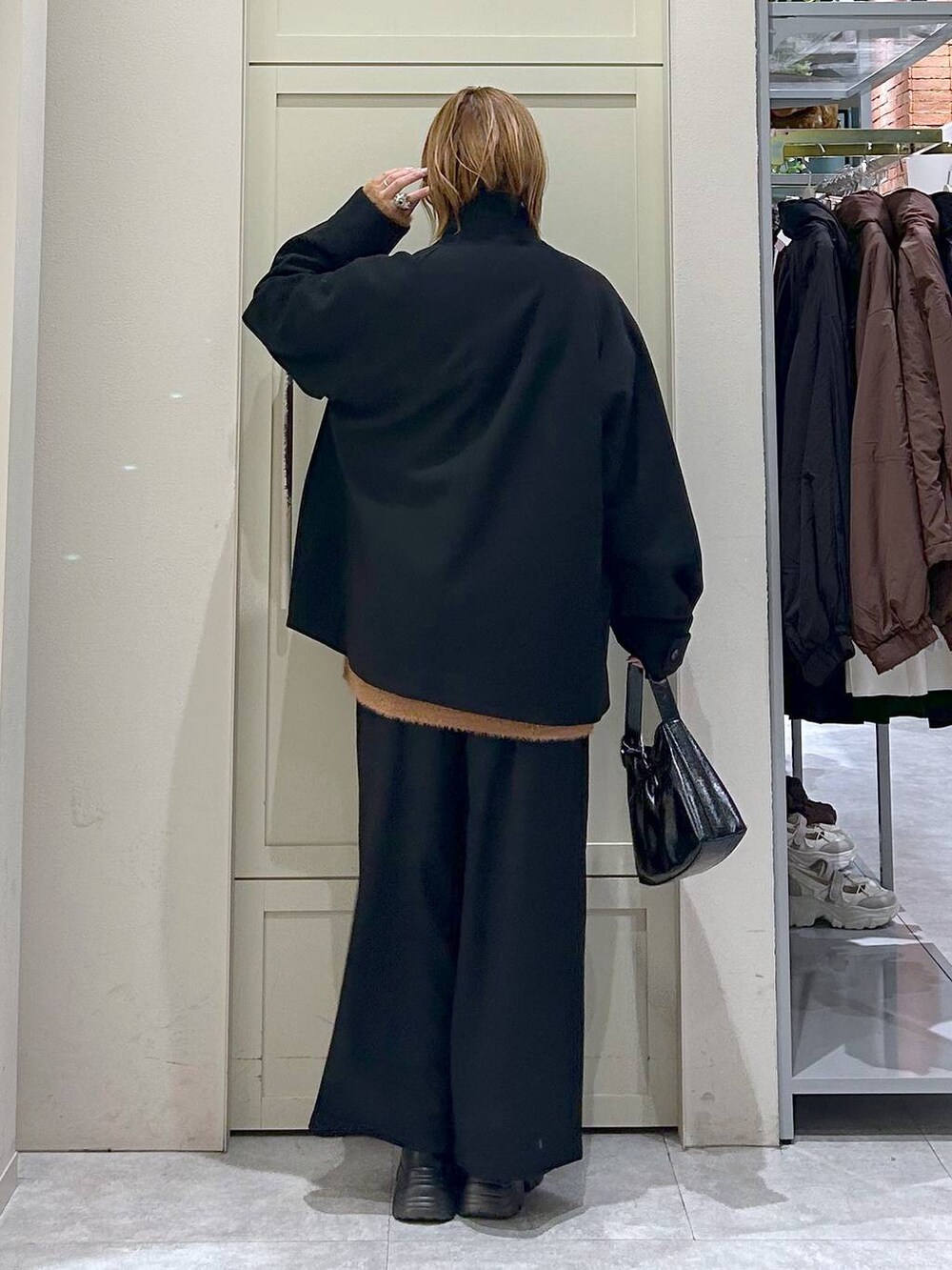 ブラック系のブーツ、ブラック系のその他パンツ、ブラック系のショルダーバッグを着用したレディースの冬コーディネートの3枚目の写真