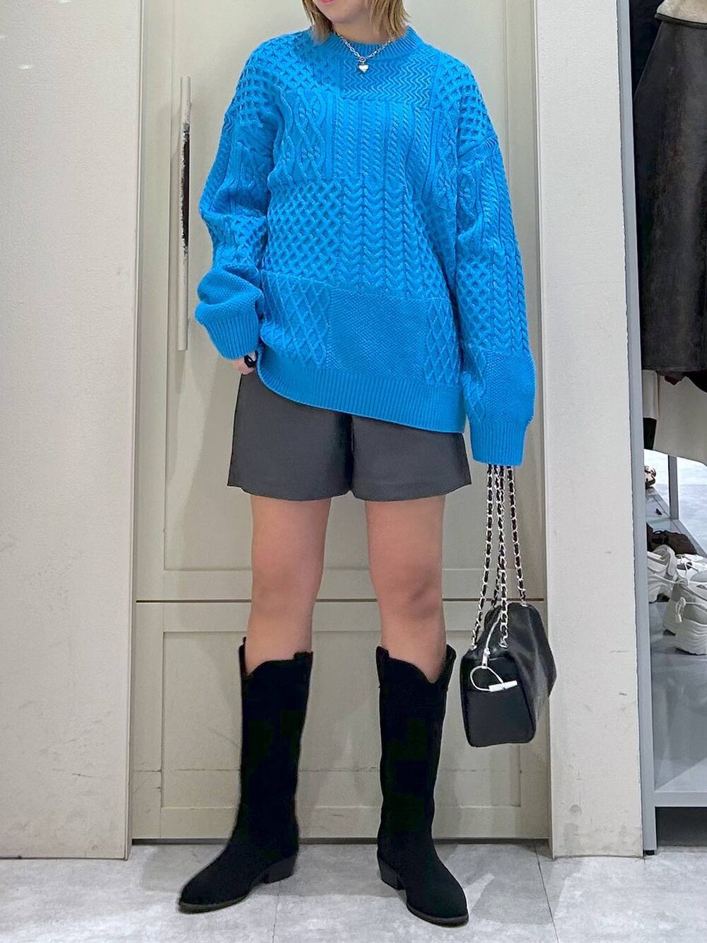 グレー系のその他パンツ、ブルー系のニット/セーター、ブラック系のショルダーバッグを着用したレディースの冬コーディネートの4枚目の写真