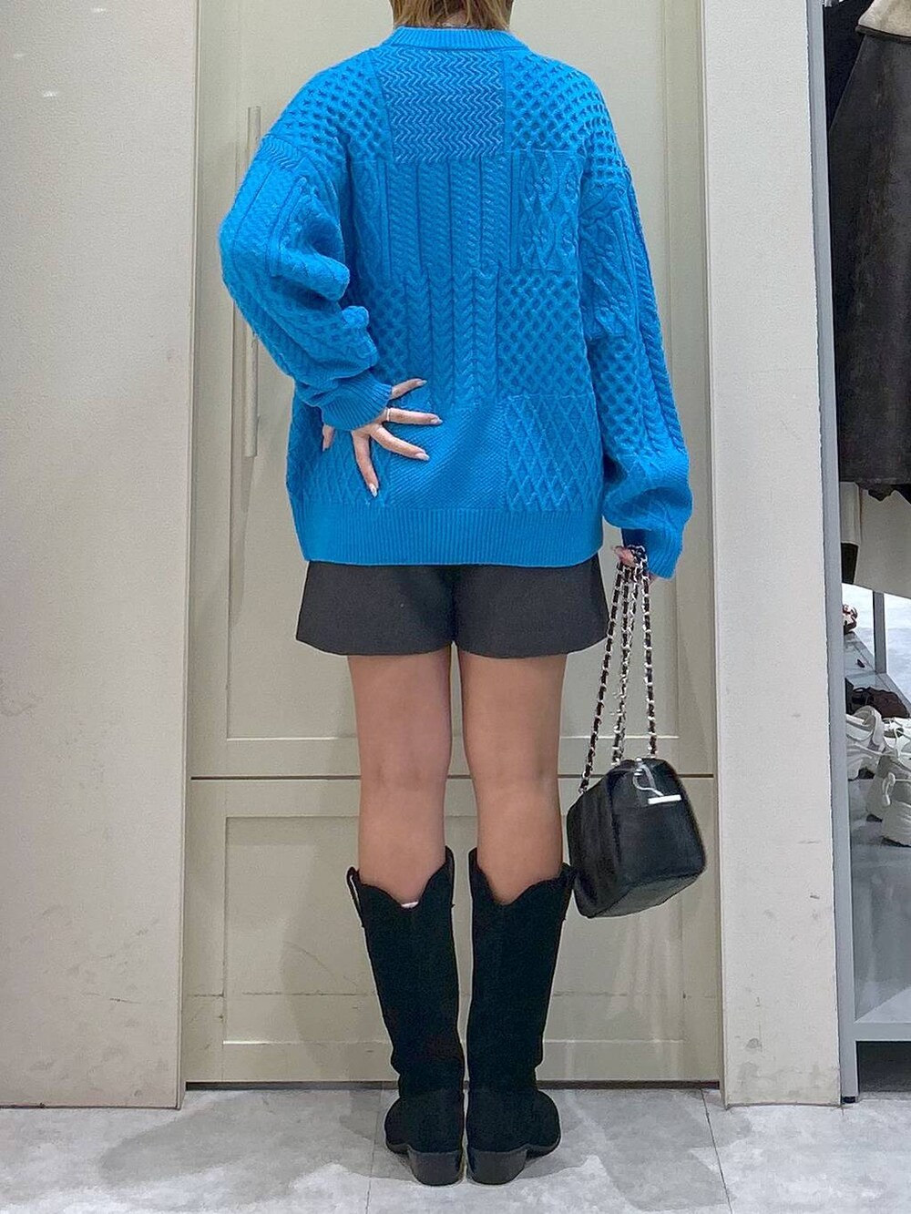 グレー系のその他パンツ、ブルー系のニット/セーター、ブラック系のショルダーバッグを着用したレディースの冬コーディネートの6枚目の写真