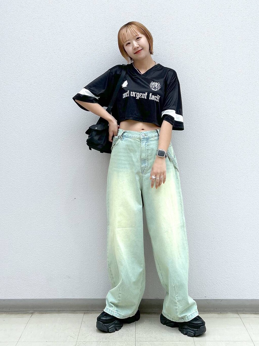 ブラック系のショルダーバッグ、ブラック系のスニーカー、ブラック系のTシャツ/カットソーを着用したレディースの春コーディネートの7枚目の写真