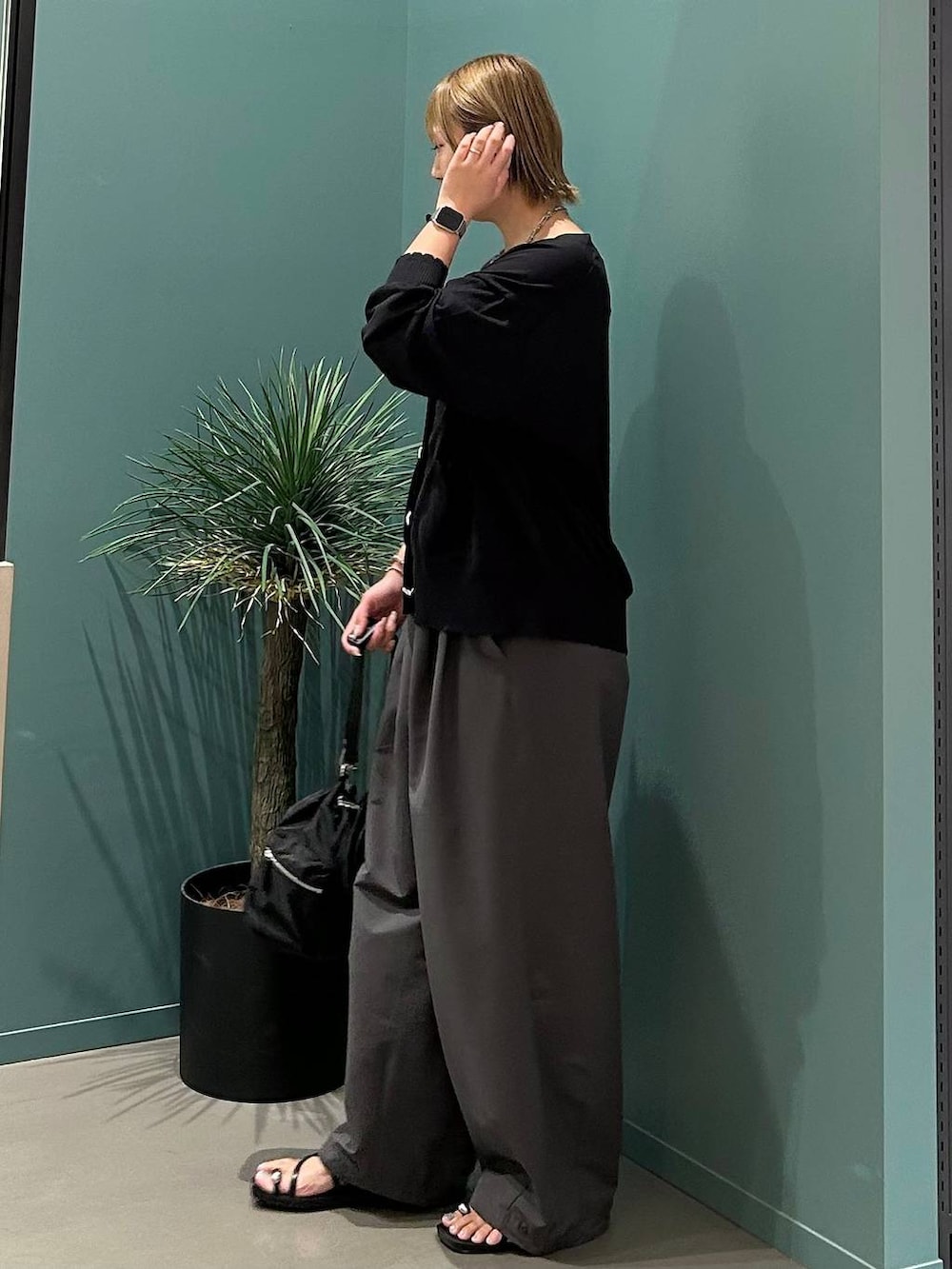 ブラック系のサンダル、グレー系のデニムパンツ、ブラック系のショルダーバッグを着用したレディースの夏コーディネートの2枚目の写真