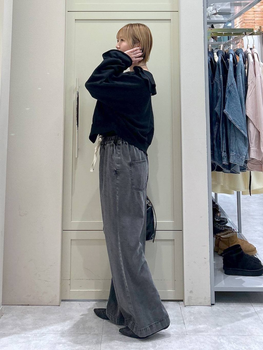 ブラック系のデニムパンツ、ブラック系のショルダーバッグ、ブラック系のパンプスを着用したレディースの冬コーディネートの2枚目の写真