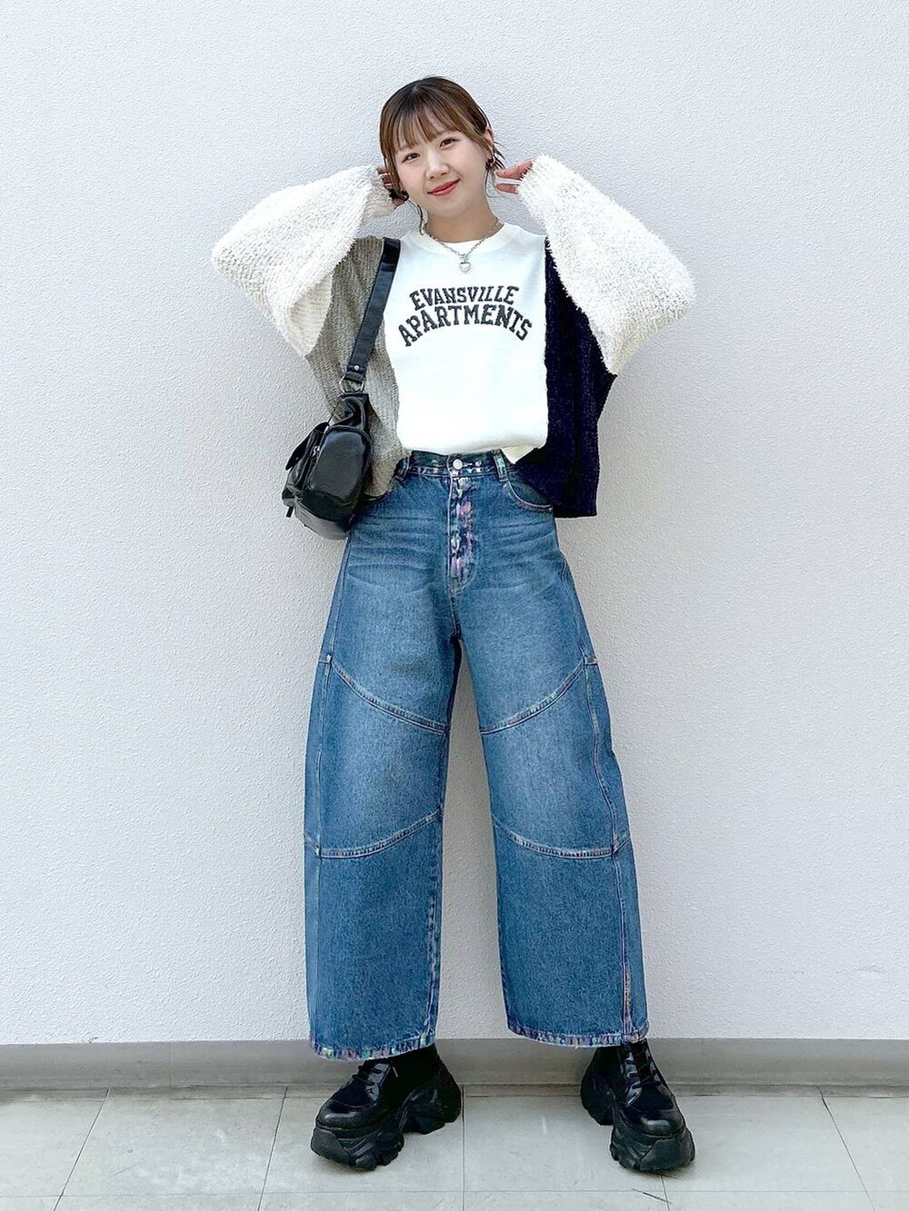 ブラック系のスニーカー、ブラック系のショルダーバッグ、ブルー系のデニムパンツを着用したレディースの冬コーディネートの7枚目の写真