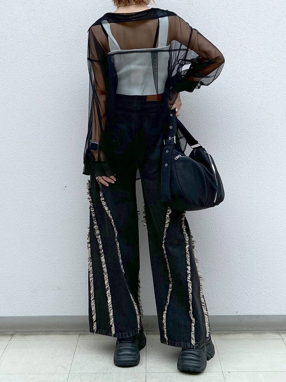 ブラック系のスニーカー、ホワイト系のタンクトップ、ブラック系のシャツ/ブラウスを着用したレディースの夏コーディネートの6枚目の写真