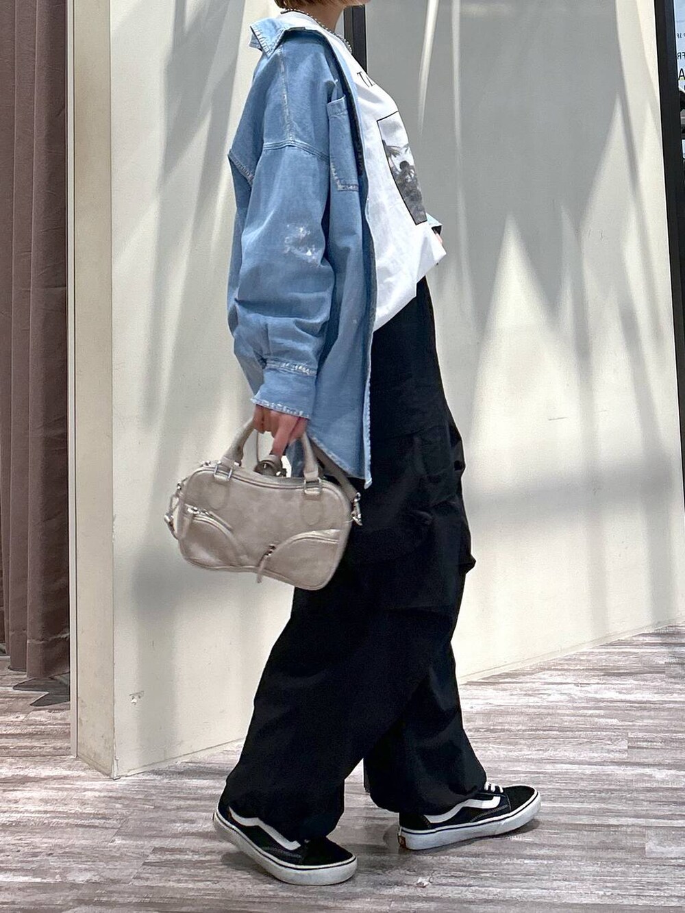 ホワイト系のTシャツ/カットソー、ブラック系のカーゴパンツ、ベージュ系のボストンバッグを着用したレディースの春コーディネートの5枚目の写真