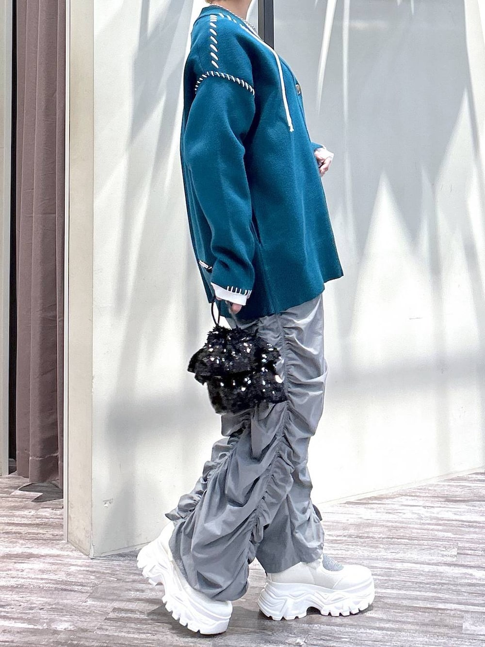 ホワイト系のニット/セーター、グレー系のその他パンツ、ブルー系のカーディガン/ボレロを着用したレディースの春コーディネートの5枚目の写真