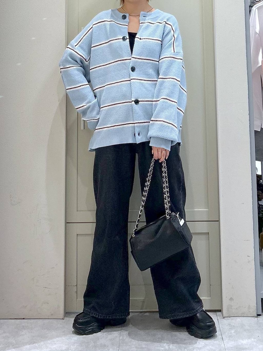 ブラック系のデニムパンツ、ブラック系のショルダーバッグ、ブラック系のローファーを着用したレディースの冬コーディネートの4枚目の写真