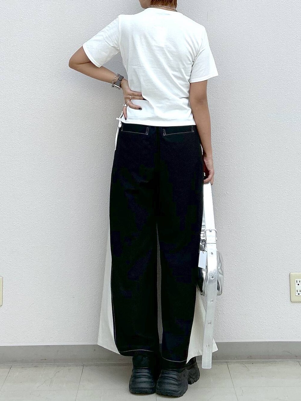 ブラック系のスニーカー、シルバー系のショルダーバッグ、ホワイト系のTシャツ/カットソーを着用したレディースの夏コーディネートの6枚目の写真