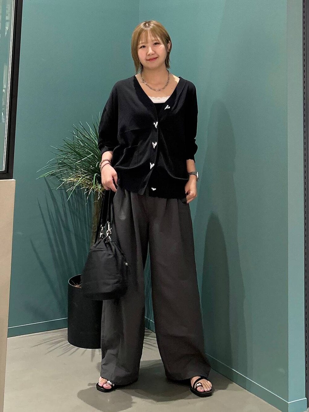 ブラック系のサンダル、グレー系のデニムパンツ、ブラック系のショルダーバッグを着用したレディースの夏コーディネートの7枚目の写真