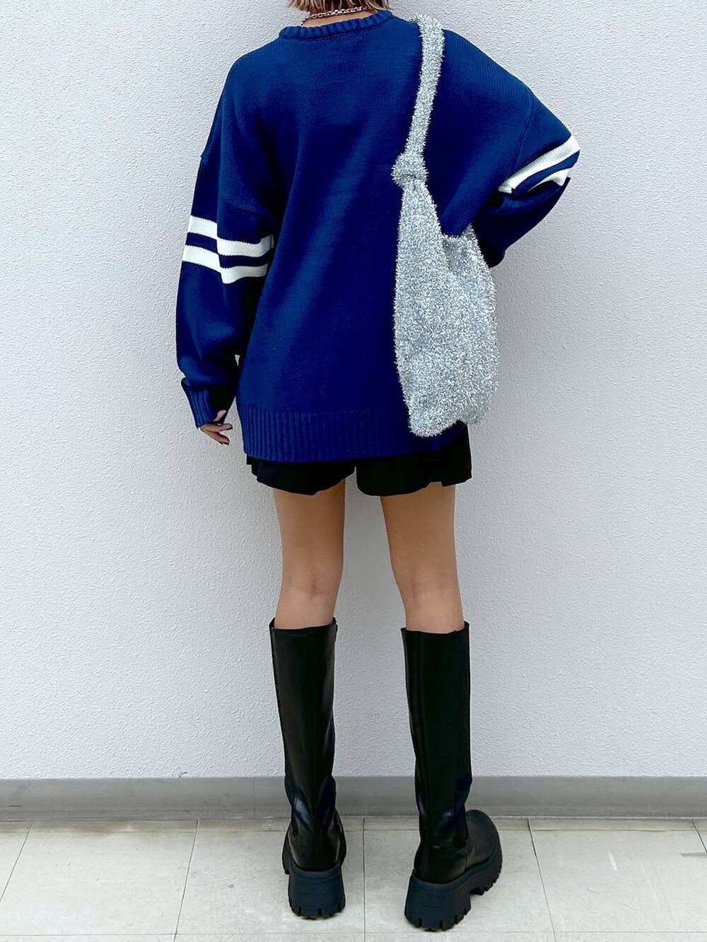 シルバー系のトートバッグ、ブラック系のブーツ、ブラック系のその他パンツを着用したレディースの秋コーディネートの6枚目の写真