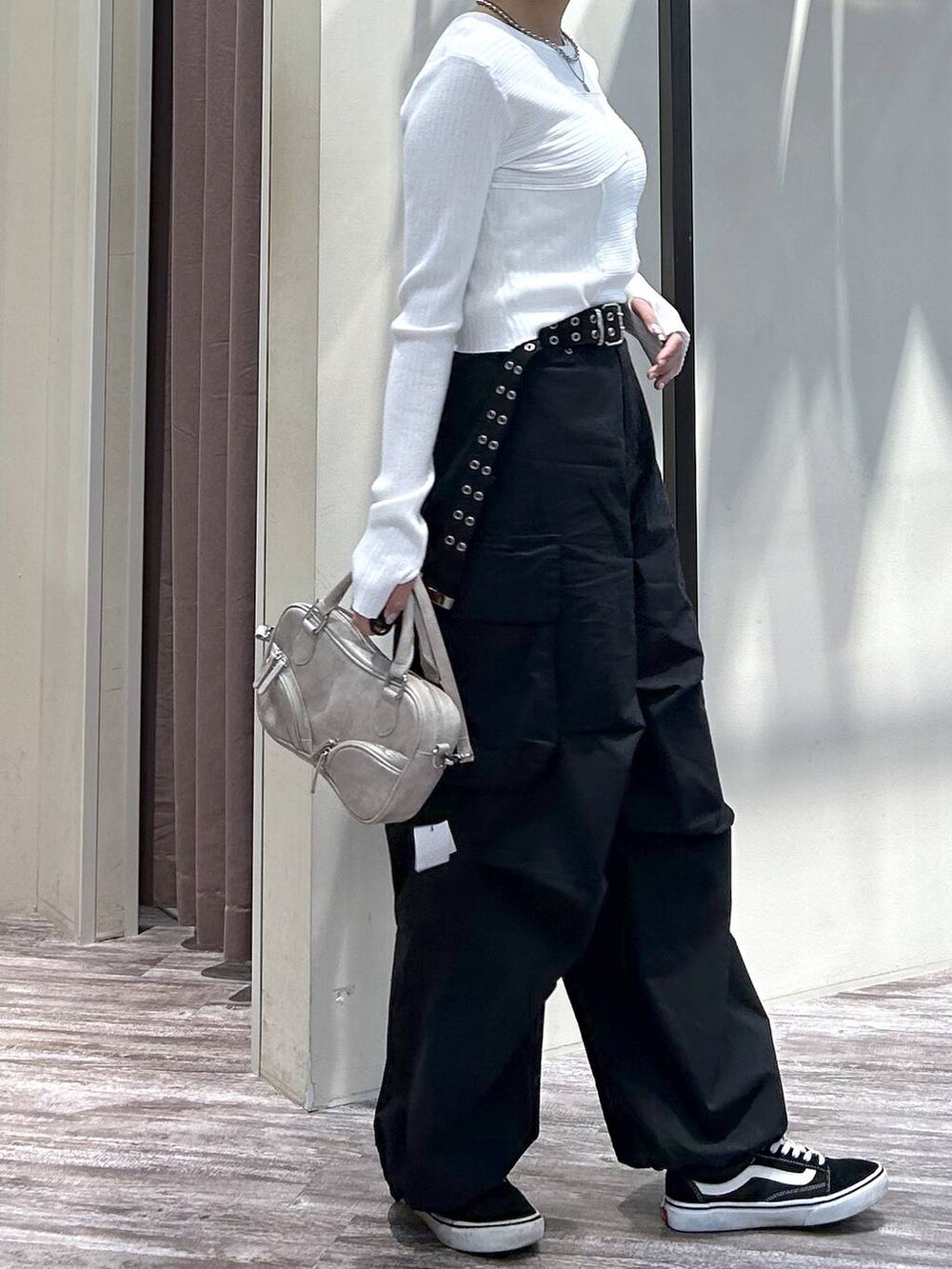 ホワイト系のニット/セーター、ブラック系のカーゴパンツ、ベージュ系のボストンバッグを着用したレディースの春コーディネートの5枚目の写真