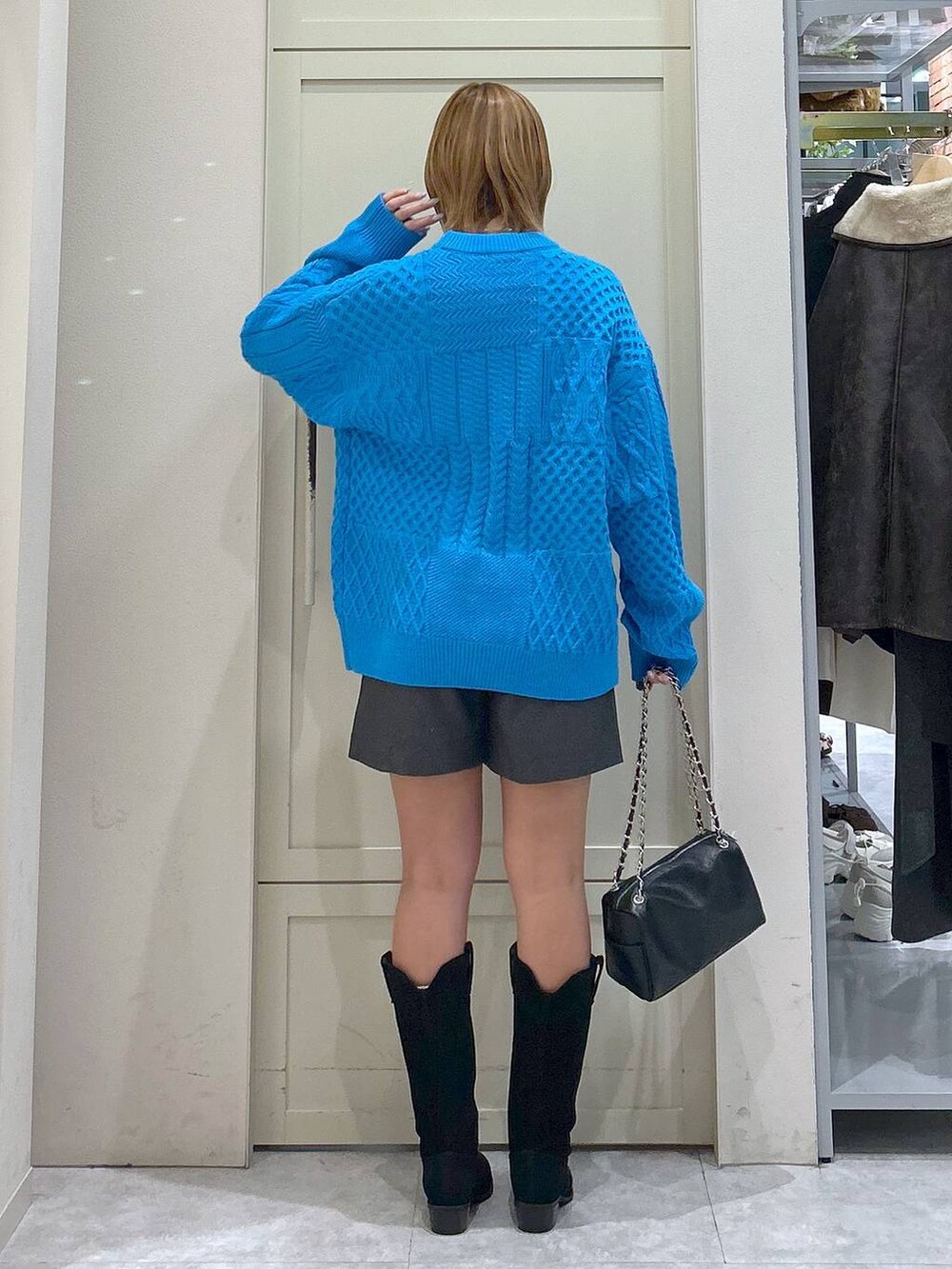 グレー系のその他パンツ、ブルー系のニット/セーター、ブラック系のショルダーバッグを着用したレディースの冬コーディネートの3枚目の写真