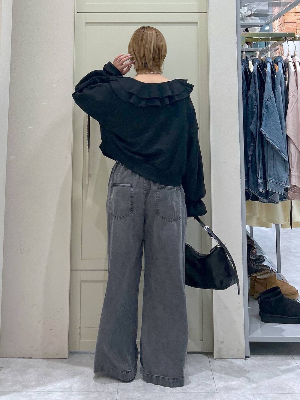 ブラック系のデニムパンツ、ブラック系のショルダーバッグ、ブラック系のパンプスを着用したレディースの冬コーディネートの3枚目の写真