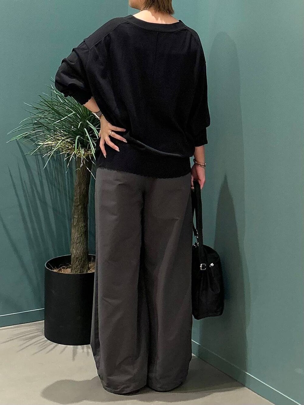 ブラック系のサンダル、グレー系のデニムパンツ、ブラック系のショルダーバッグを着用したレディースの夏コーディネートの6枚目の写真