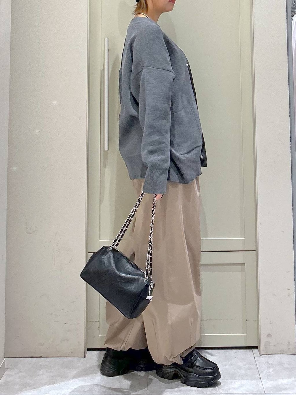 ブラック系のショルダーバッグ、ブラック系のローファー、ベージュ系のその他パンツを着用したレディースの冬コーディネートの5枚目の写真