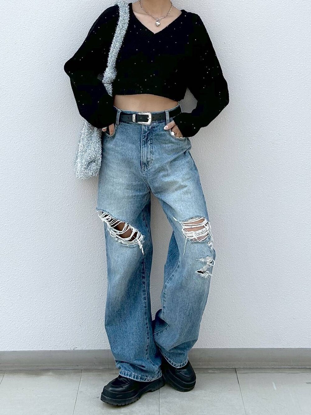 ブラック系のブーツ、ブルー系のデニムパンツ、シルバー系のトートバッグを着用したレディースの冬コーディネートの4枚目の写真