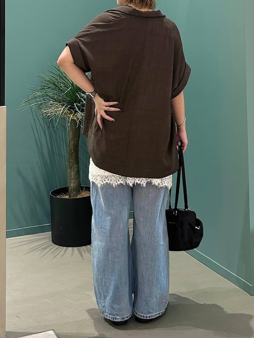 ブルー系のデニムパンツ、ブラウン系のテーラードジャケット、ブラック系のサンダルを着用したレディースの夏コーディネートの6枚目の写真