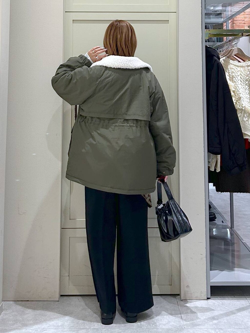 ブラック系のスラックス、グリーン系のその他アウター、ブラック系のローファーを着用したレディースの冬コーディネートの3枚目の写真