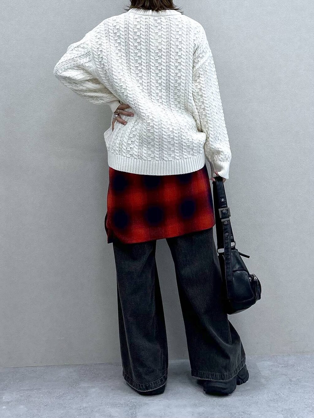 ブラック系のスニーカー、ブラック系のデニムパンツ、ブラック系のショルダーバッグを着用したレディースの冬コーディネートの6枚目の写真