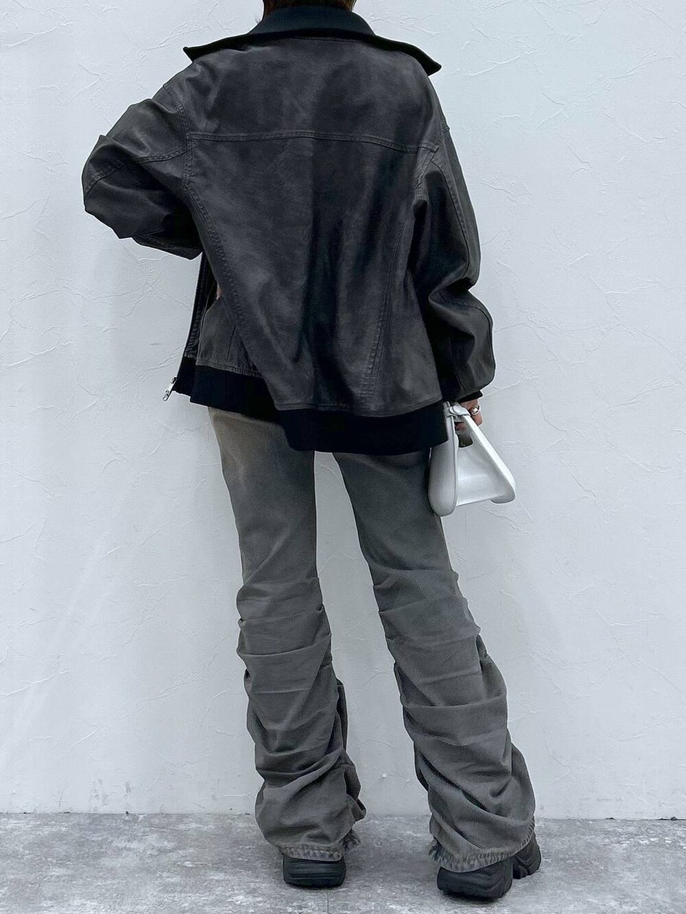 ブラック系のスニーカー、ブルー系のデニムパンツ、ブラック系のブルゾンを着用したレディースの秋コーディネートの6枚目の写真