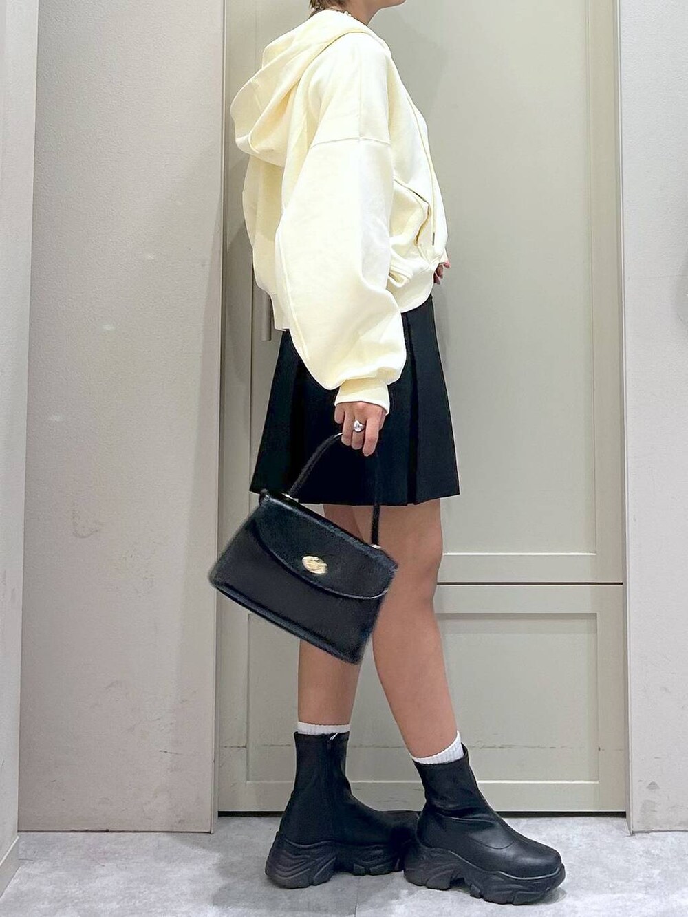 ブラック系のブーツ、ブラック系のボストンバッグ、グレー系のスカートを着用したレディースの秋コーディネートの5枚目の写真