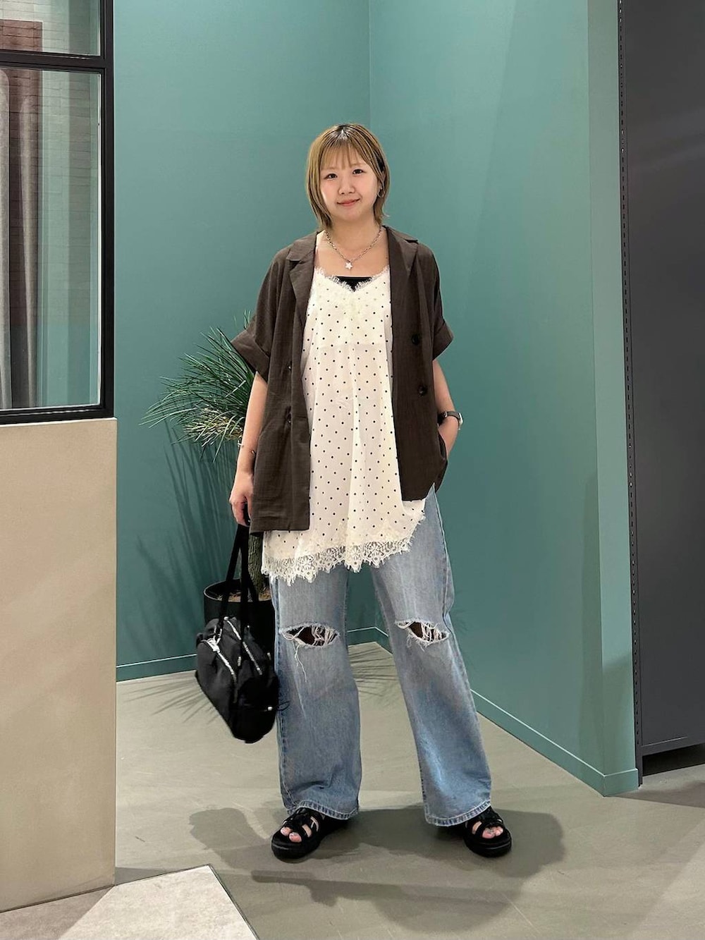 ブルー系のデニムパンツ、ブラウン系のテーラードジャケット、ブラック系のサンダルを着用したレディースの夏コーディネートの7枚目の写真