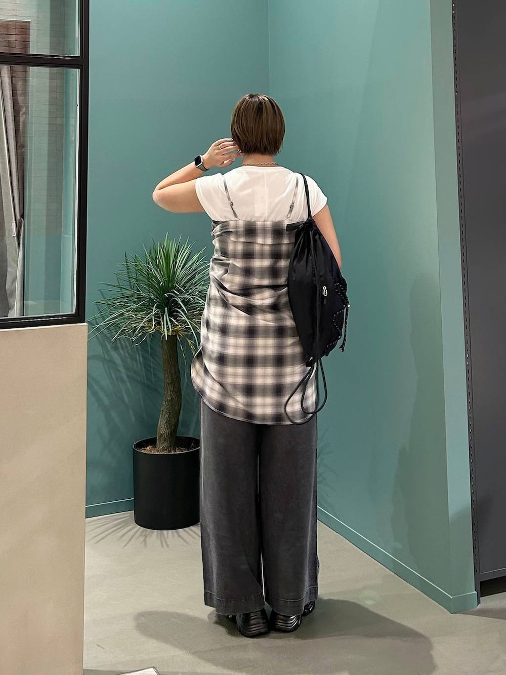 ホワイト系のTシャツ/カットソー、ブラック系のローファー、ブラック系のバックパック/リュックを着用したレディースの夏コーディネートの3枚目の写真