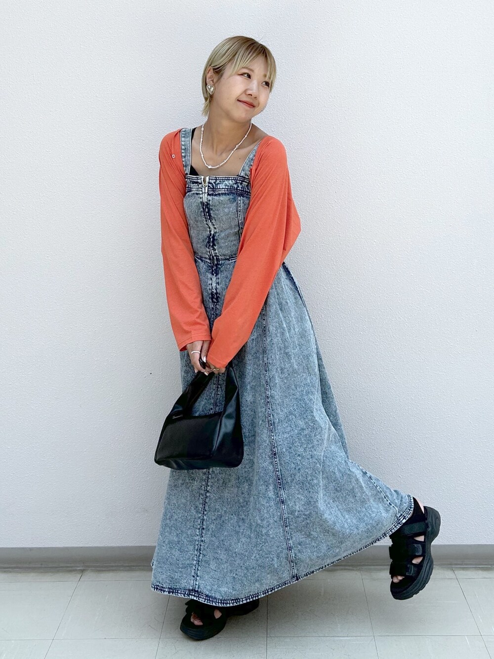 オレンジ系のカーディガン/ボレロ、ブルー系のジャンパースカートを着用したレディースの夏コーディネートの7枚目の写真